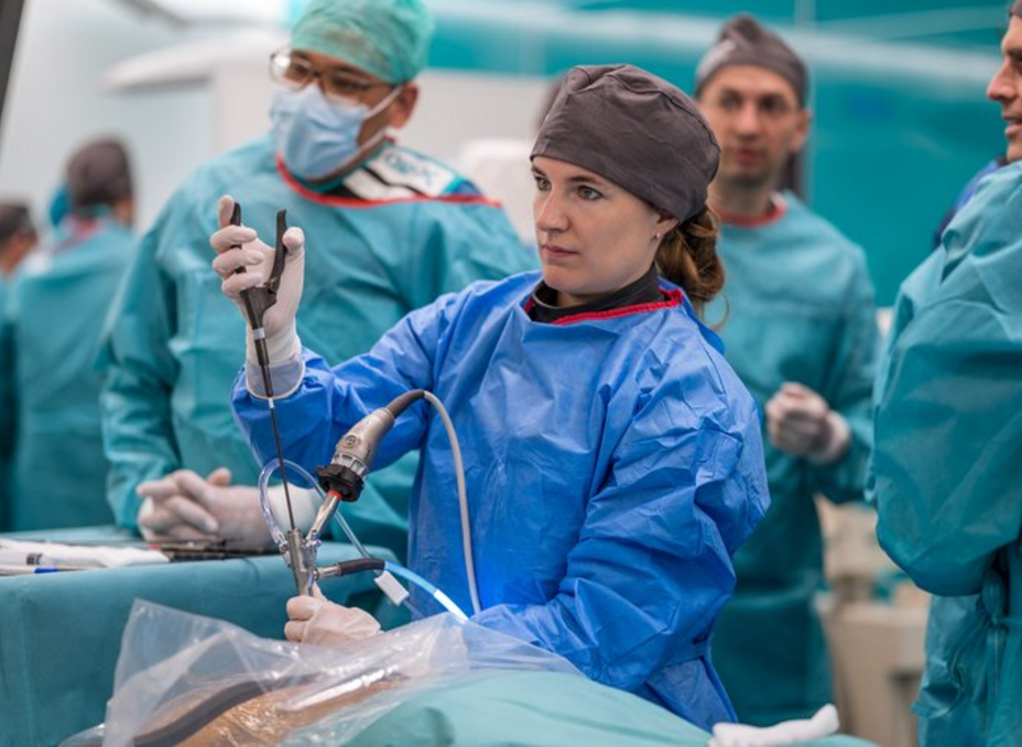 Surgeon performing an endoscopy in the OP-X while being observed by experienced instructors.
