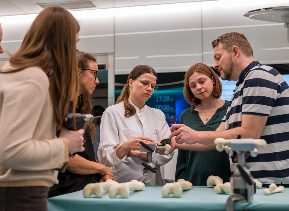 Prof. Thomas Dreher explains a paediatric procedure to Anna Schuler and her fellow residents using a model as part of a resident course in the OR-X.