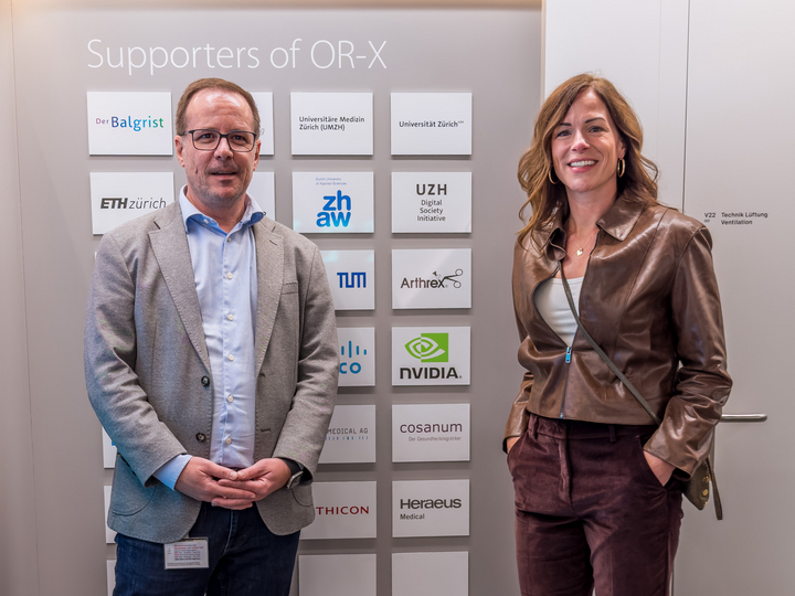 Prof. Philipp Fürnstahl and Kimberly Powell standing in front of the OR-X supporter's wall