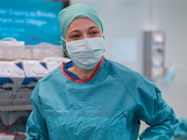 Anna Schuler smiles and wears surgical protective clothing during a training session in the OR-X