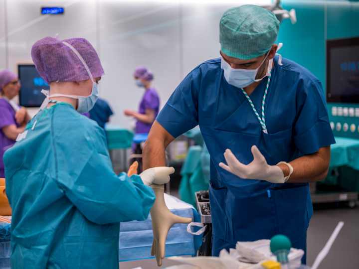  A surgical technician helps a medical student how to put on a sterile surgical glove.