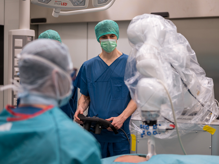 An engineer and surgeon operate the KUKA robot, which records ultrasound images.