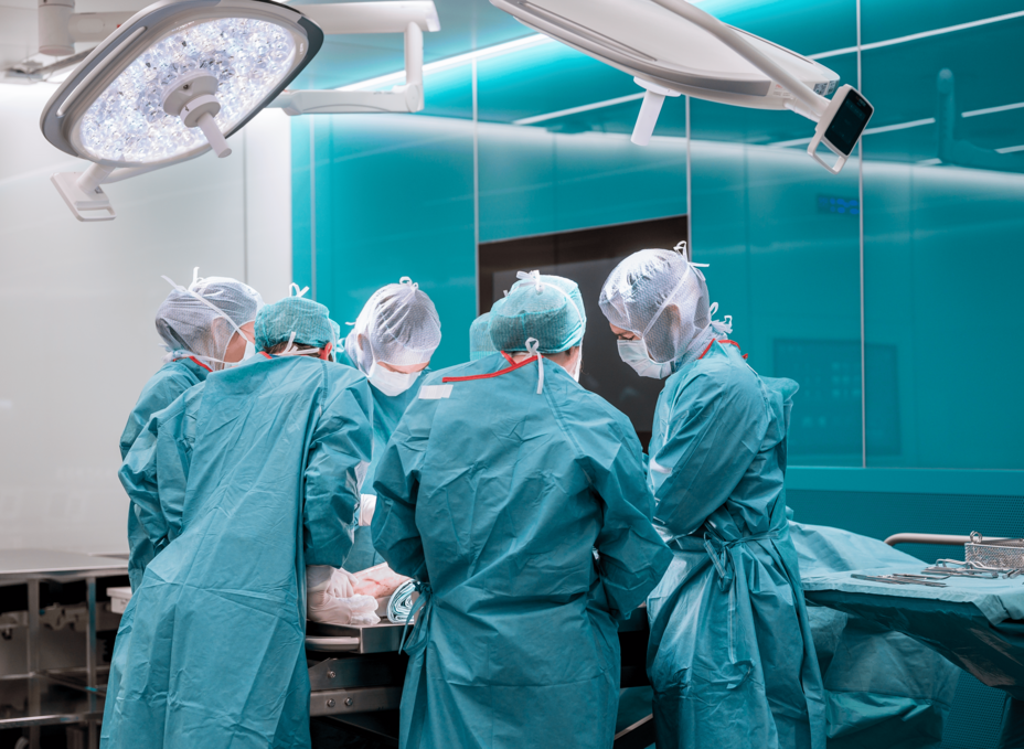A group of surgeons working on a operating table in the OR-X