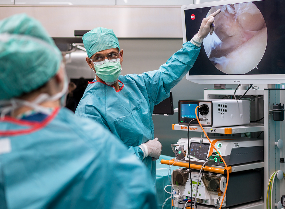 A senior surgeons pointing on a screen in the OR showing some live images of a shoulder arthroscopy.