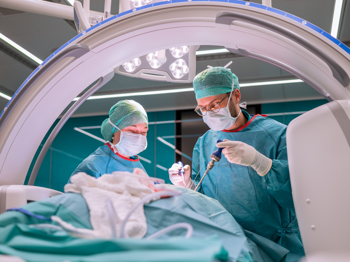 Anna Schuler and a surgeon operate below a C-arm.