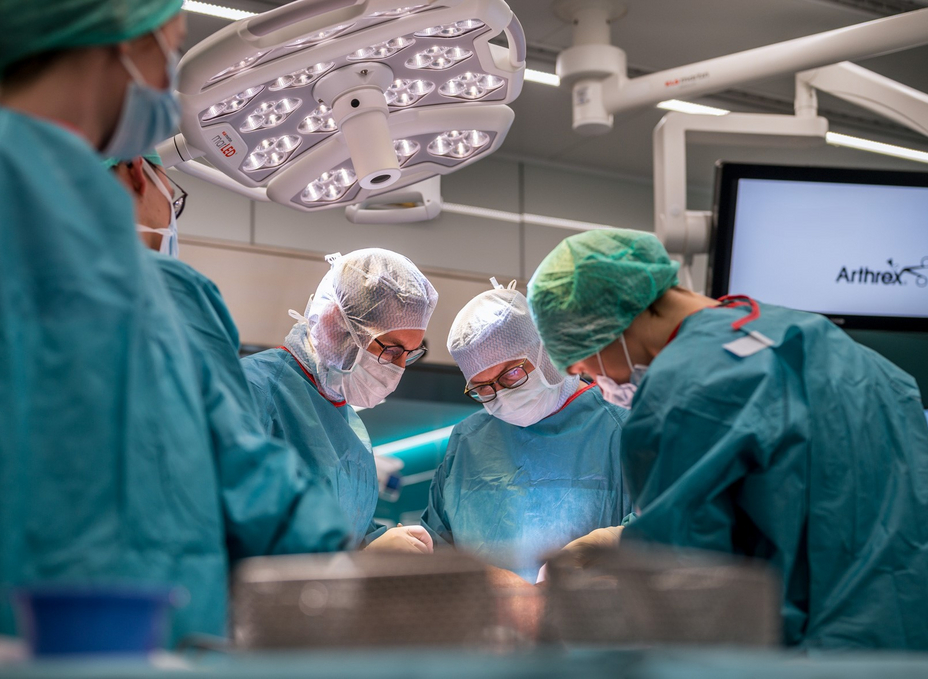 A group of 4 surgeons working on a specimen as part of an arthroplasty course in the OR-X.